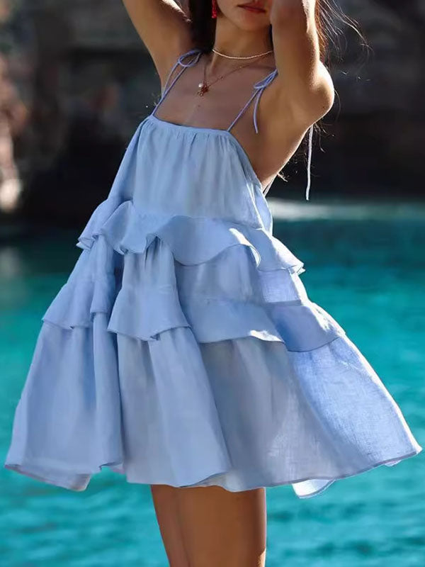 Robe courte ample superposée plissée nouée taille haute, dos nu, à fines bretelles, couleur unie