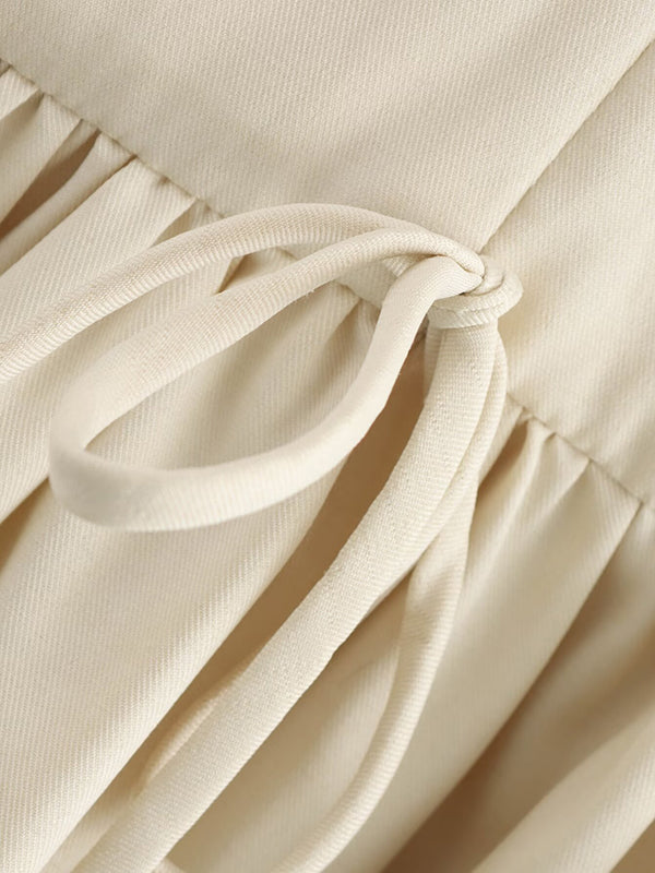 Robe courte ample plissée coupe trapèze, à empiècements, à fermeture éclair, à col rond, couleur unie