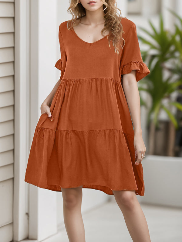 Robe courte plissée volantée coupe trapèze, à manches évasées, à poches, à empiècements, à col rond, couleur unie