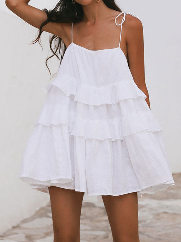 Robe courte ample superposée plissée nouée taille haute, dos nu, à fines bretelles, couleur unie