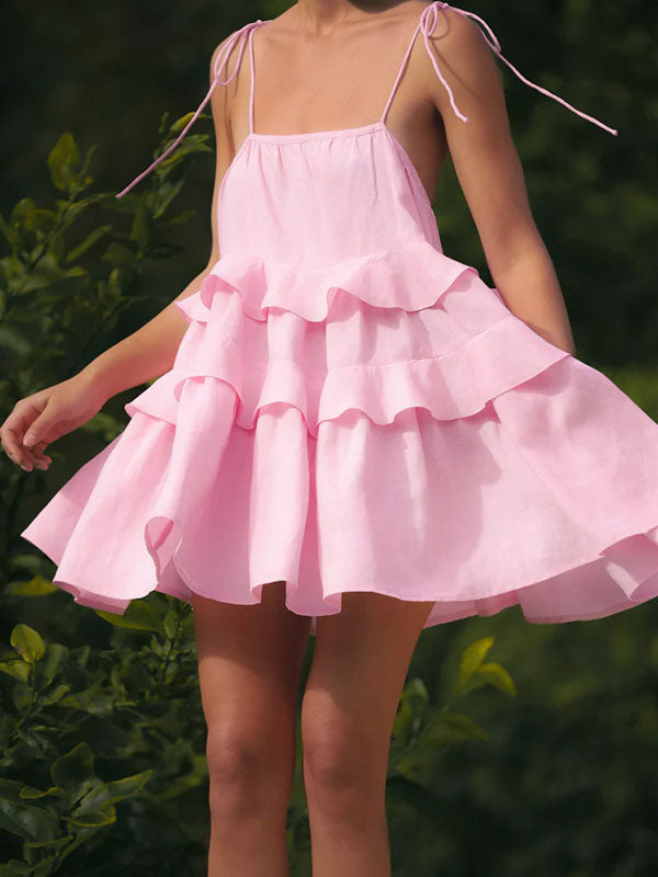 Robe courte ample superposée plissée nouée taille haute, dos nu, à fines bretelles, couleur unie