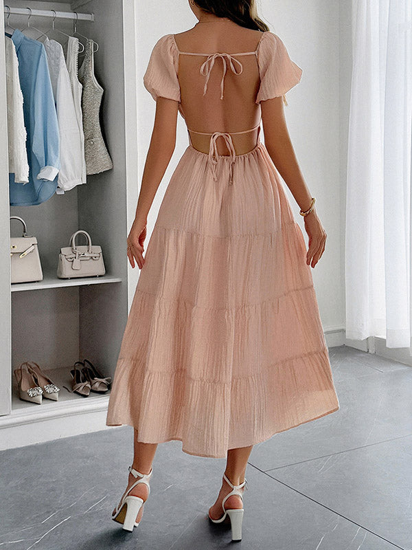Robe mi-longue ample plissée nouée coupe trapèze, dos nu, à col en V, couleur unie
