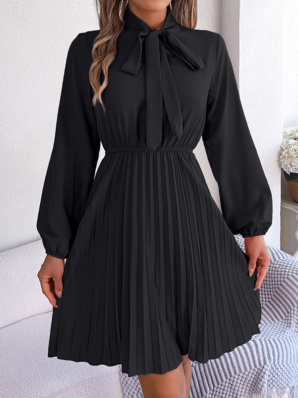 Robe courte ample plissée nouée à manches longues, à col cheminée, couleur unie