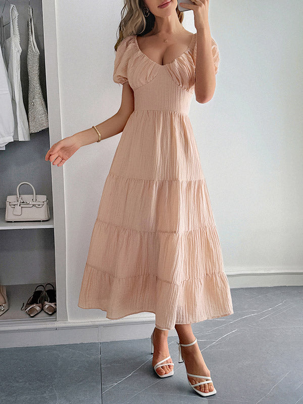 Robe mi-longue ample plissée nouée coupe trapèze, dos nu, à col en V, couleur unie