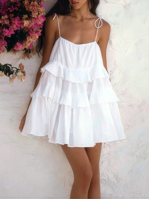 Robe courte superposée plissée coupe trapèze, taille haute, dos nu, à fines bretelles, couleur unie