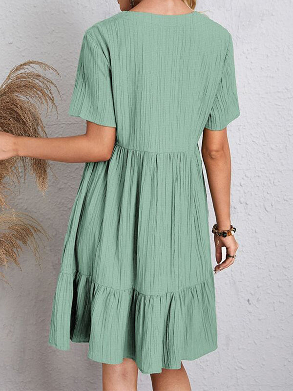 Robe courte ample plissée coupe trapèze, à empiècements, à col en V, couleur unie