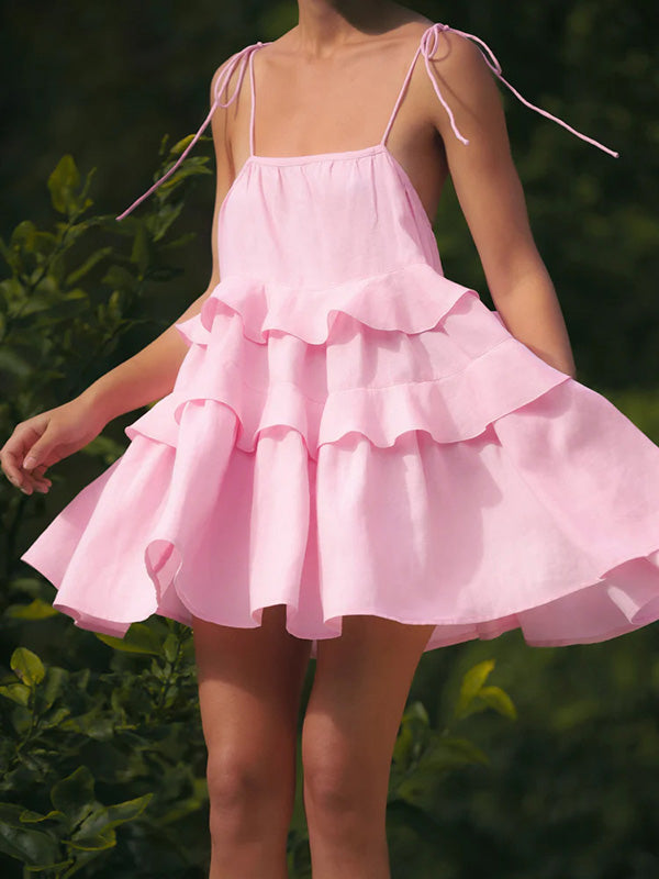 Robe courte superposée plissée coupe trapèze, taille haute, dos nu, à fines bretelles, couleur unie