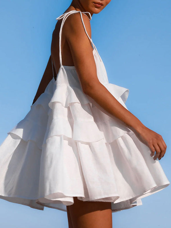 Robe courte superposée plissée coupe trapèze, taille haute, dos nu, à fines bretelles, couleur unie