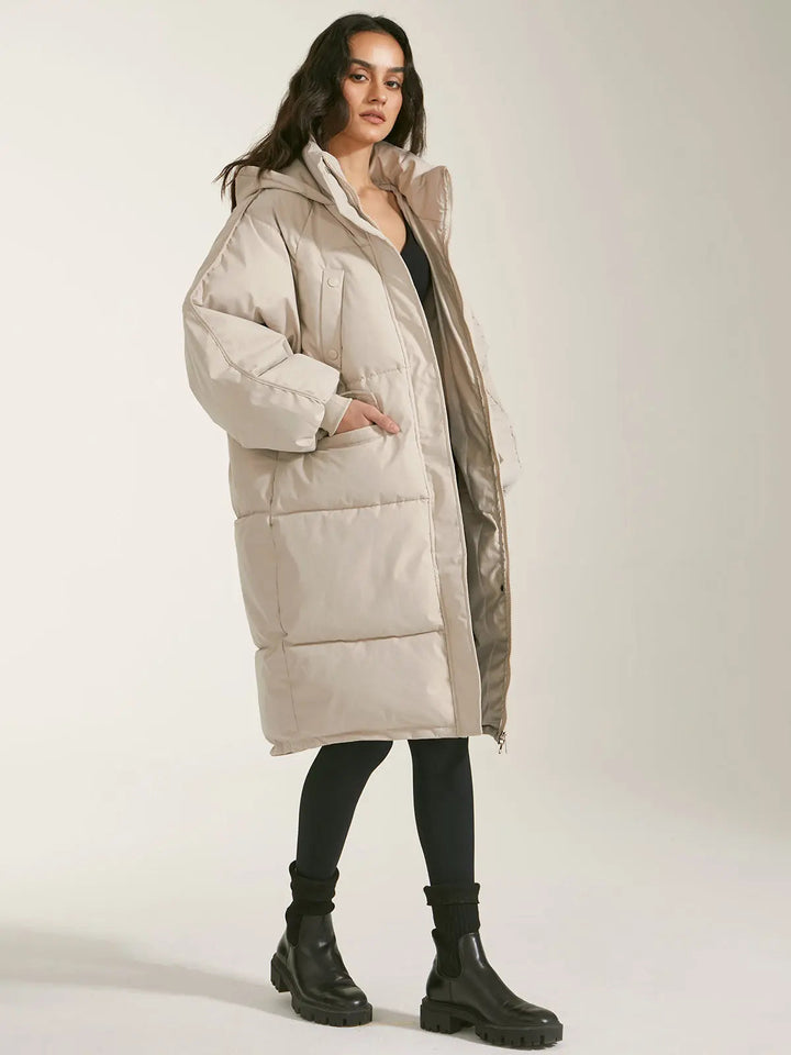 Manteau Long Matelassé pour Femmes avec Capuche, Fermeture Frontale et Poches Latérales