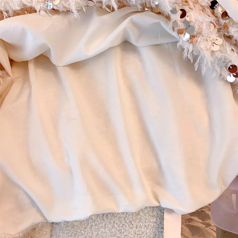 Pull femme avec décolleté bateau et surface à franges ainsi que décorations en sequins