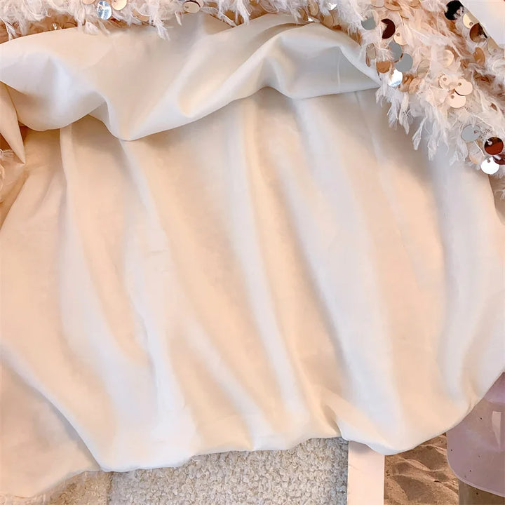Pull femme avec décolleté bateau et surface à franges ainsi que décorations en sequins