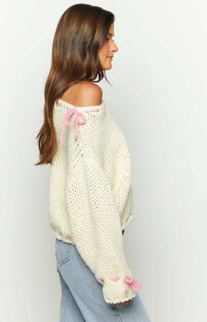 Pull en laine pour femmes avec un large décolleté bateau et des détails en nœud rose