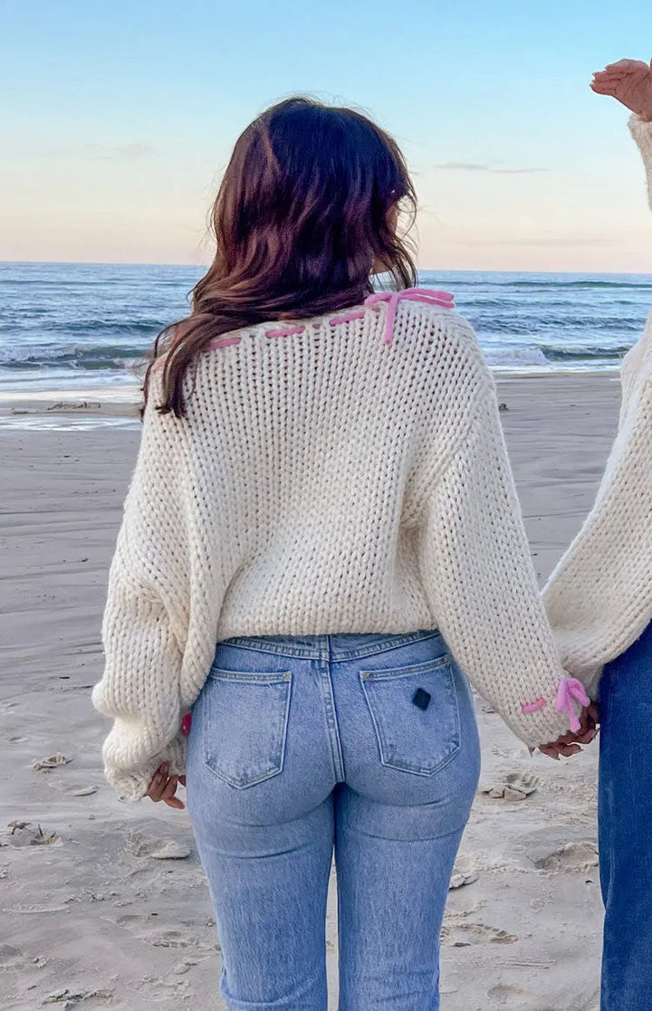 Pull en laine pour femmes avec un large décolleté bateau et des détails en nœud rose