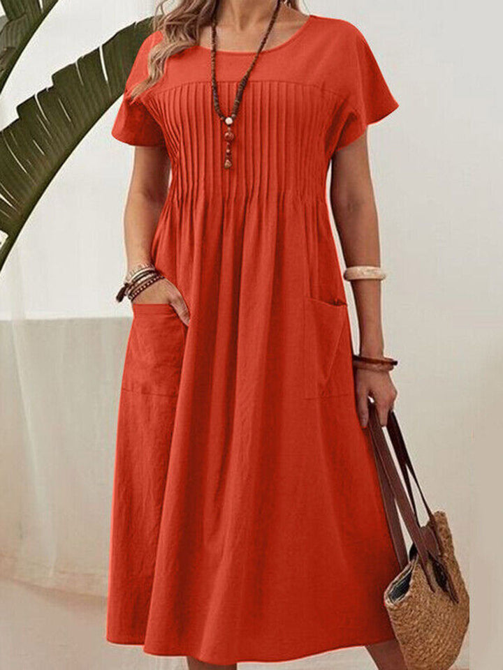 Robe mi-longue ample plissée taille haute, à poches, à empiècements, à col rond, couleur unie