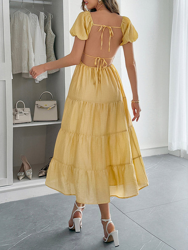 Robe mi-longue ample plissée nouée coupe trapèze, dos nu, à col en V, couleur unie