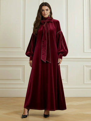 Robe longue plissée coupe trapèze, à manches longues, à nœud, à empiècements, à col haut, couleur unie