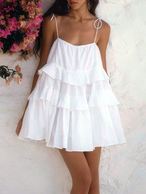 Robe courte ample superposée plissée nouée taille haute, dos nu, à fines bretelles, couleur unie
