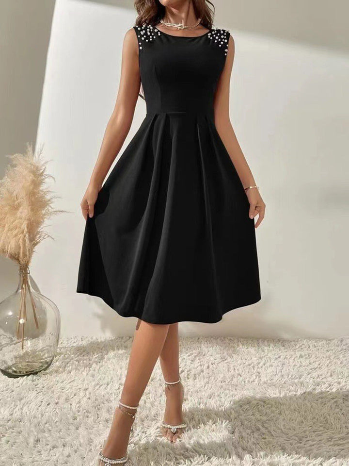 Robe courte plissée coupe trapèze, taille haute, à perles, à empiècements, à col rond, couleur unie